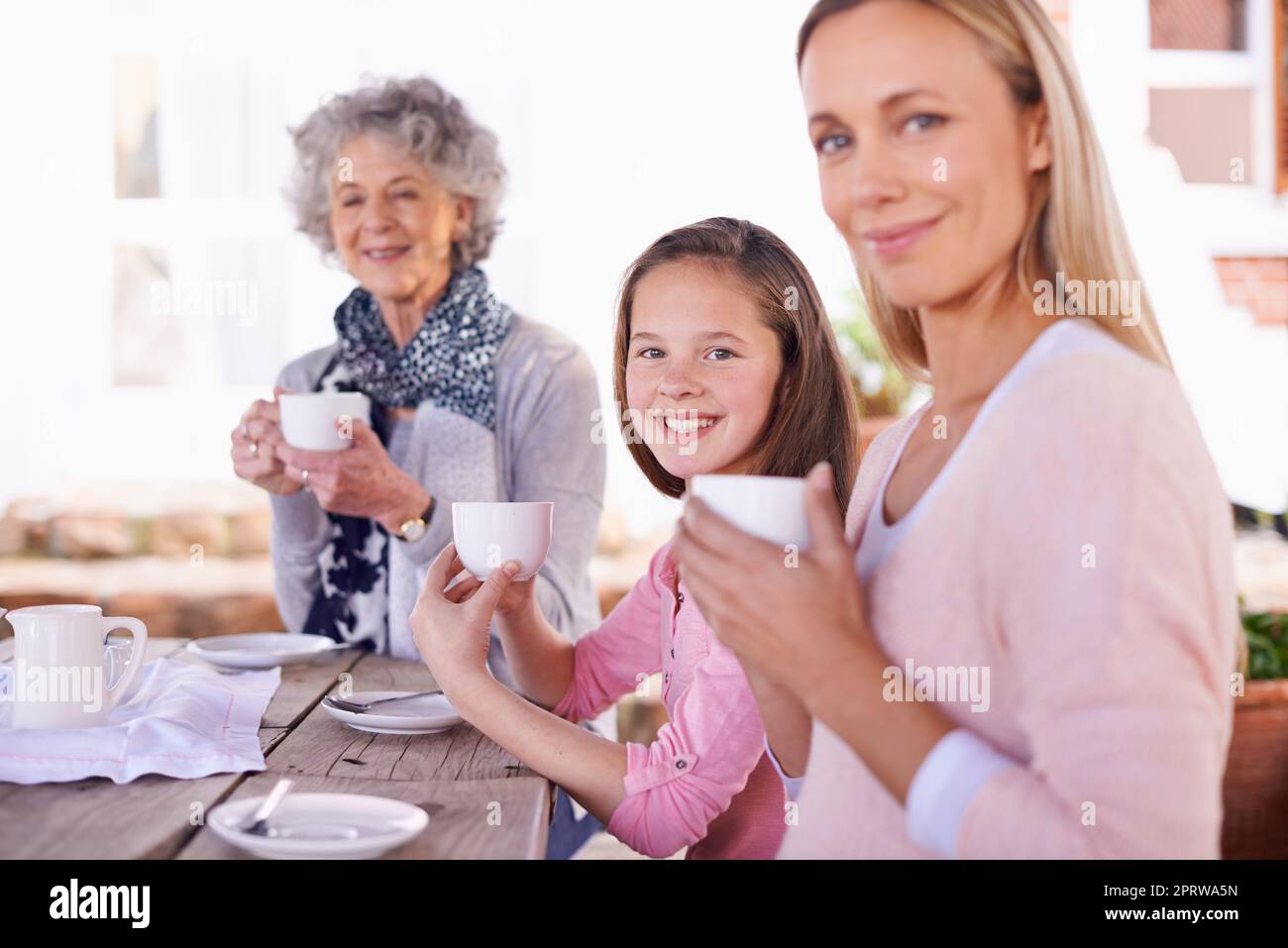 Happiness is a cup of tea. three generations of the woman of the women of a family having tea outside. Stock Photo