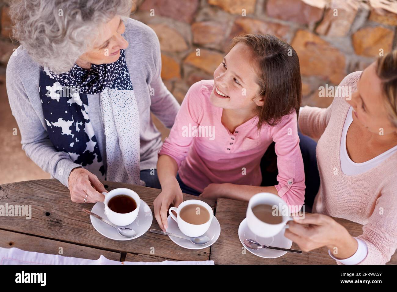 These girls love their tea. three generations of the woman of the women of a family having tea outside. Stock Photo