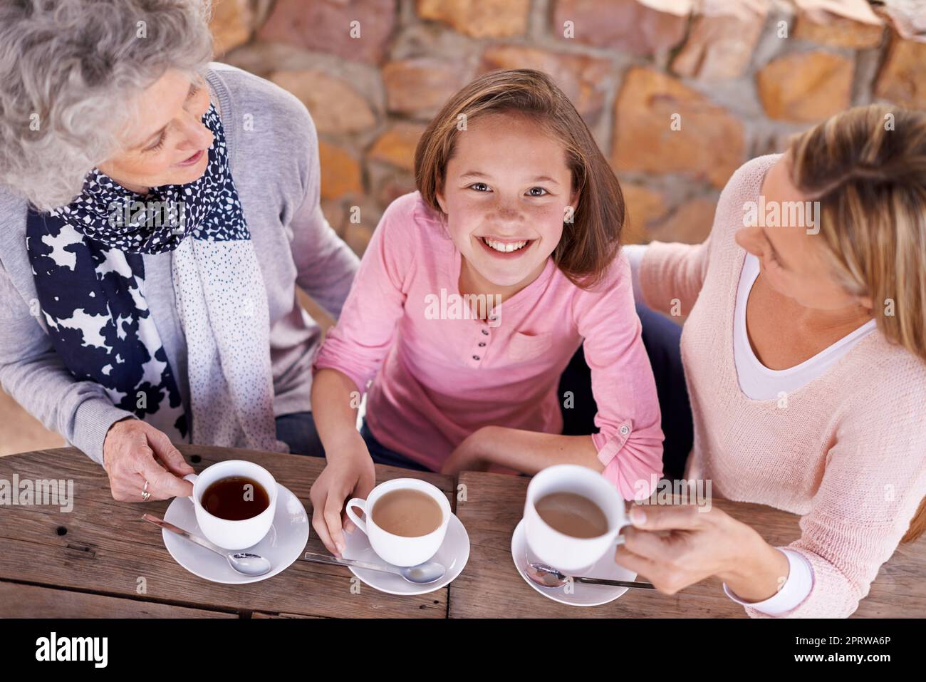Learning from mother to mother. three generations of the woman of the women of a family having tea outside. Stock Photo