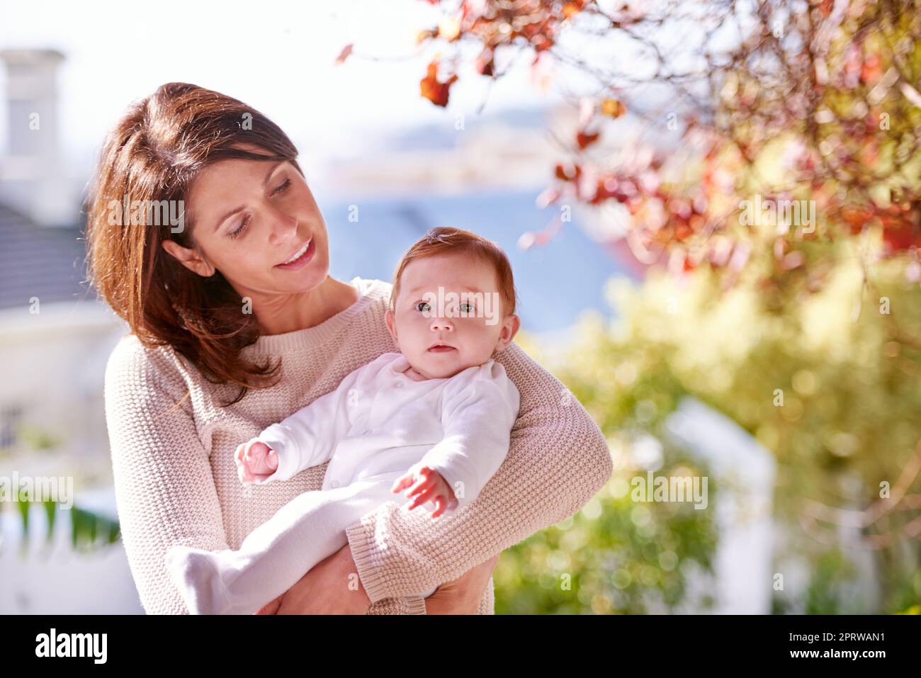 Shes her pride and joy. A woman holding her cute baby outdoors. Stock Photo