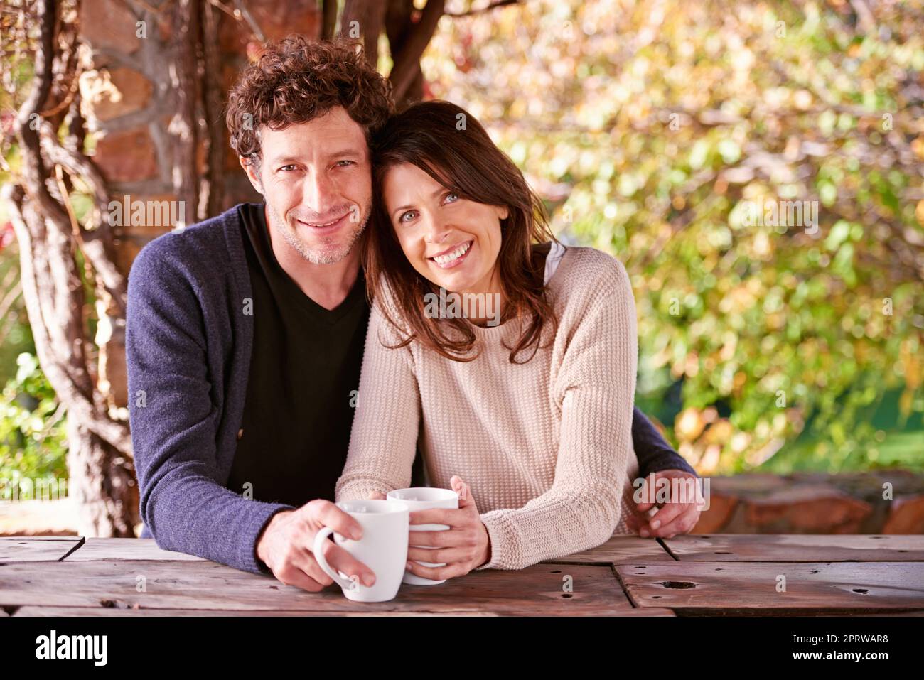 Tea-time tenderness. Portrait of a mature couple embracing in the outdoors. Stock Photo