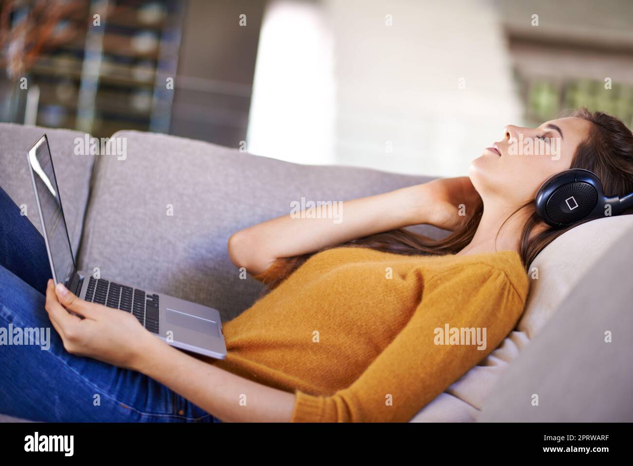 Her favorite pastime. An attractive young woman listening to music while napping. Stock Photo