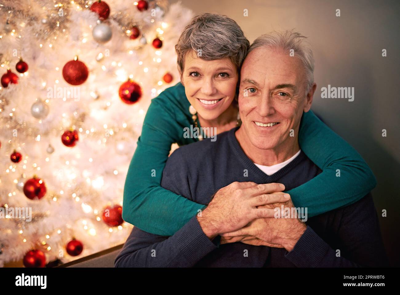 Wheres that mistletoe. Cropped portrait of a happy mature couple sitting in their home at Christmastime. Stock Photo