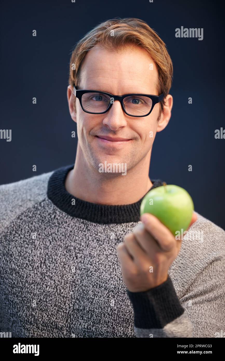 Keep calm and be a gentlemen. a man holding a apple in a studio. Stock Photo