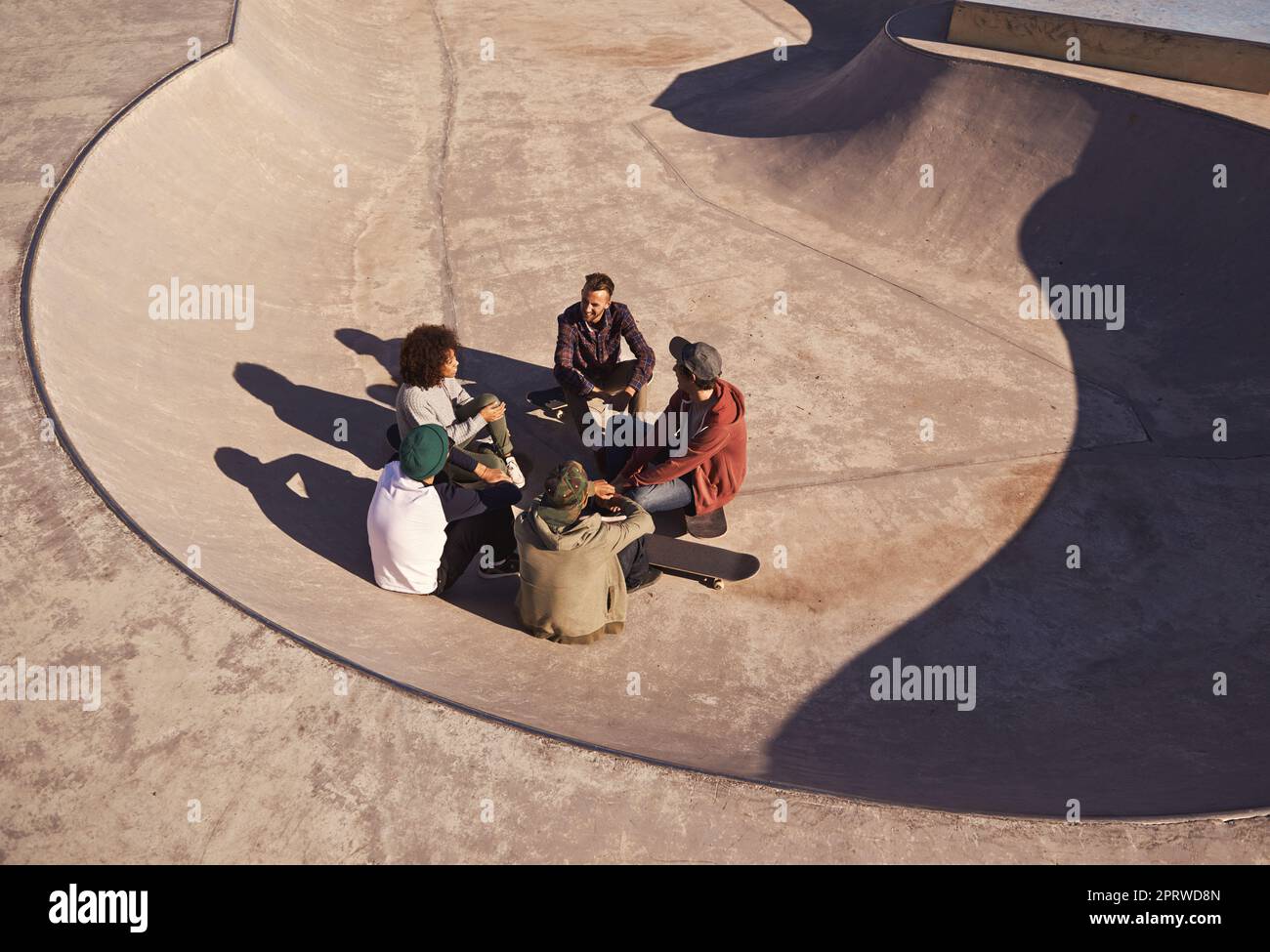 In their natural habitat. a group of friends hanging out in the sun at a skate park. Stock Photo