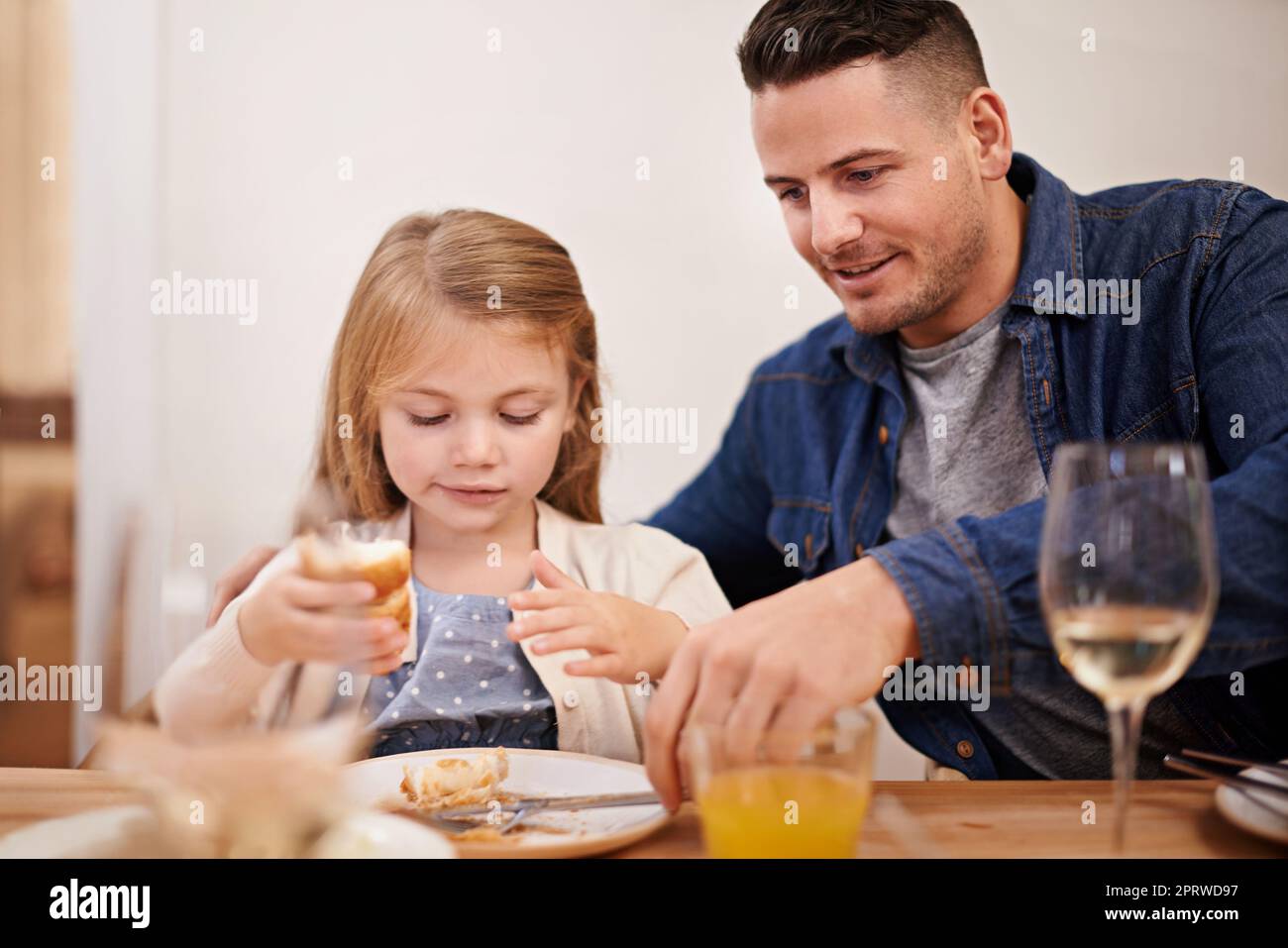 You finished, honey. a young father and his daughter sitting down to family dinner. Stock Photo