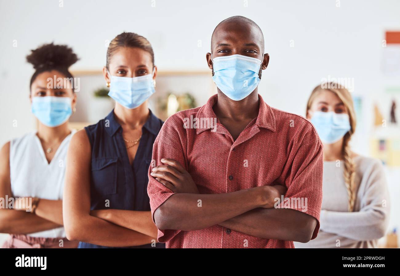 Covid, face mask and colleagues standing for safety and health in creative office with diversity, hygiene and leadership. Portrait of business people in healthy workplace during coronavirus Stock Photo