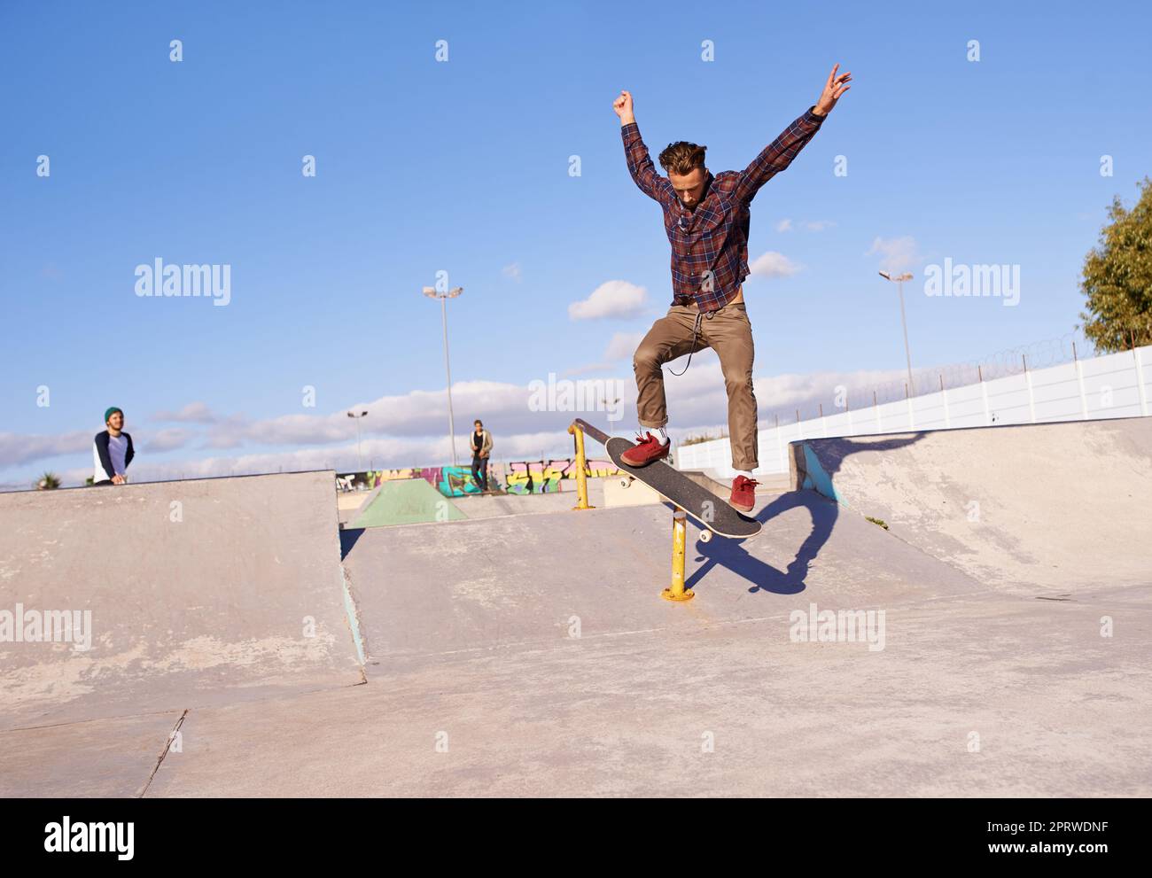 Have you see the skills on this one. A young man doing tricks on his skateboard at the skate park. Stock Photo