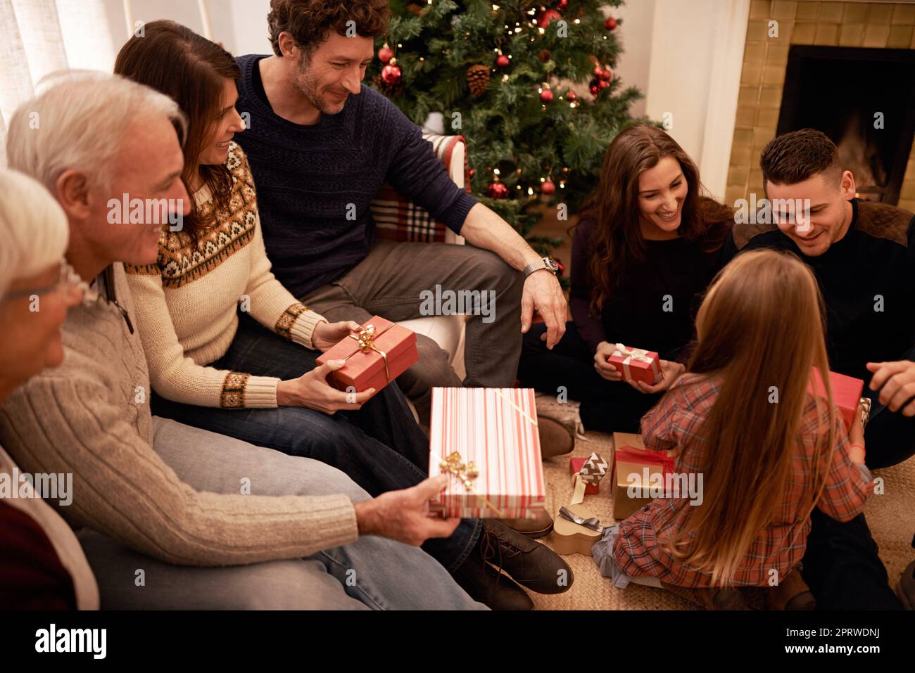 Enjoying a cosy family Christmas. a a family giving presents at christmas. Stock Photo
