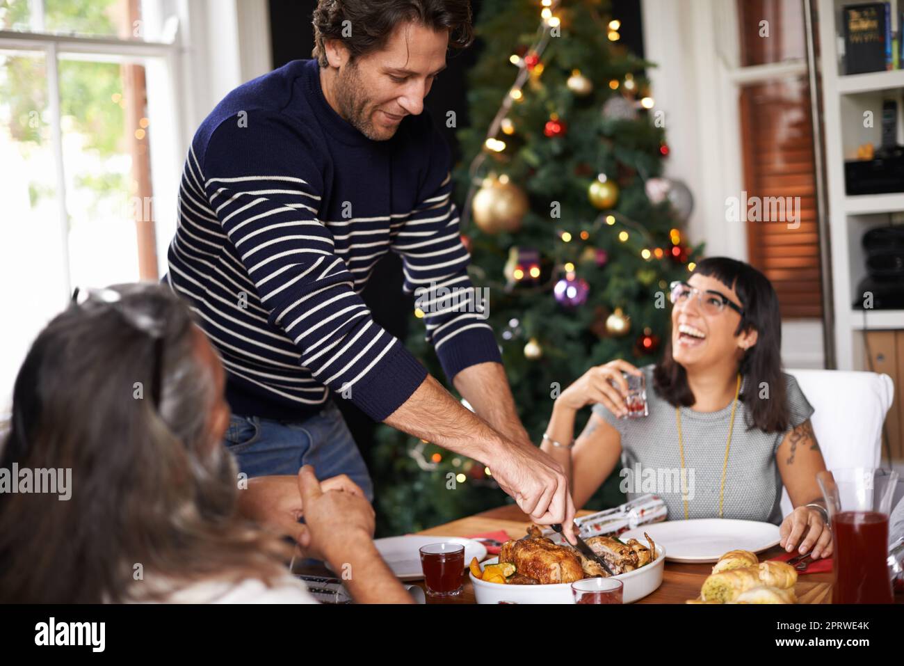 Carve faster - were hungry. a man carving a chicken on Christmas. Stock Photo
