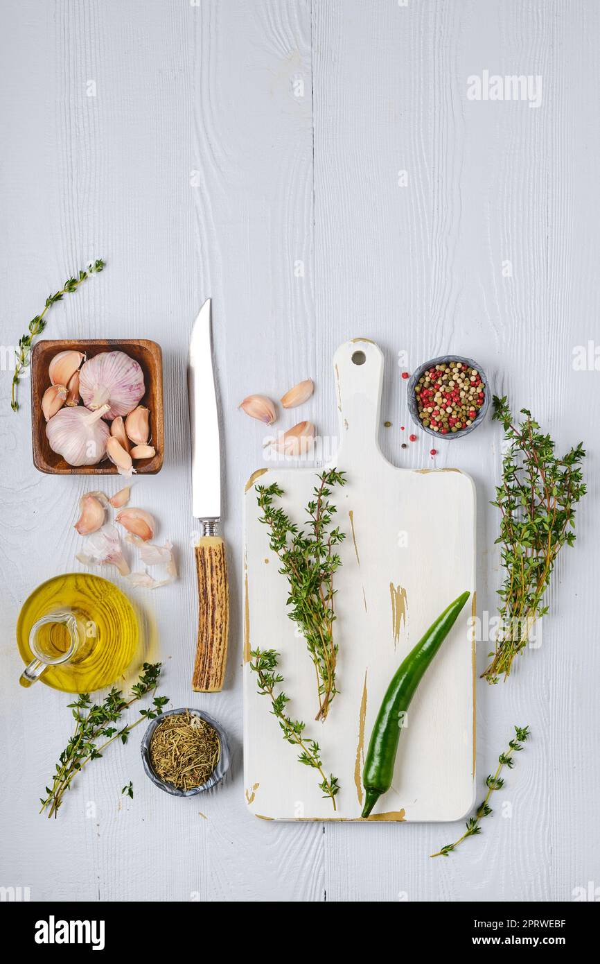 Top view of wooden cutting board with fresh thyme and spices for piquant sauce or marinade Stock Photo