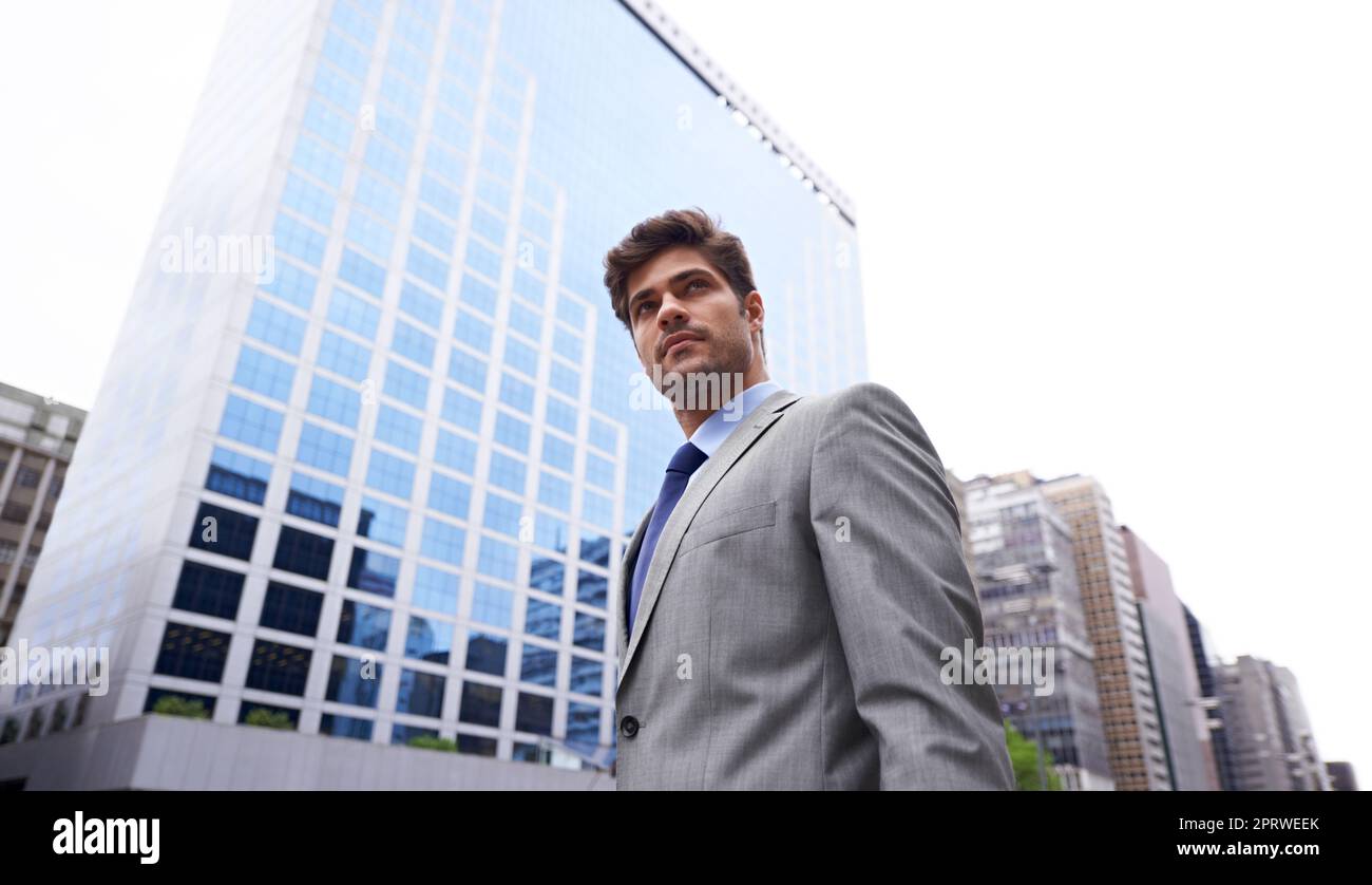 He means business. A low angle shot of a handsome young businessman standing in the city. Stock Photo