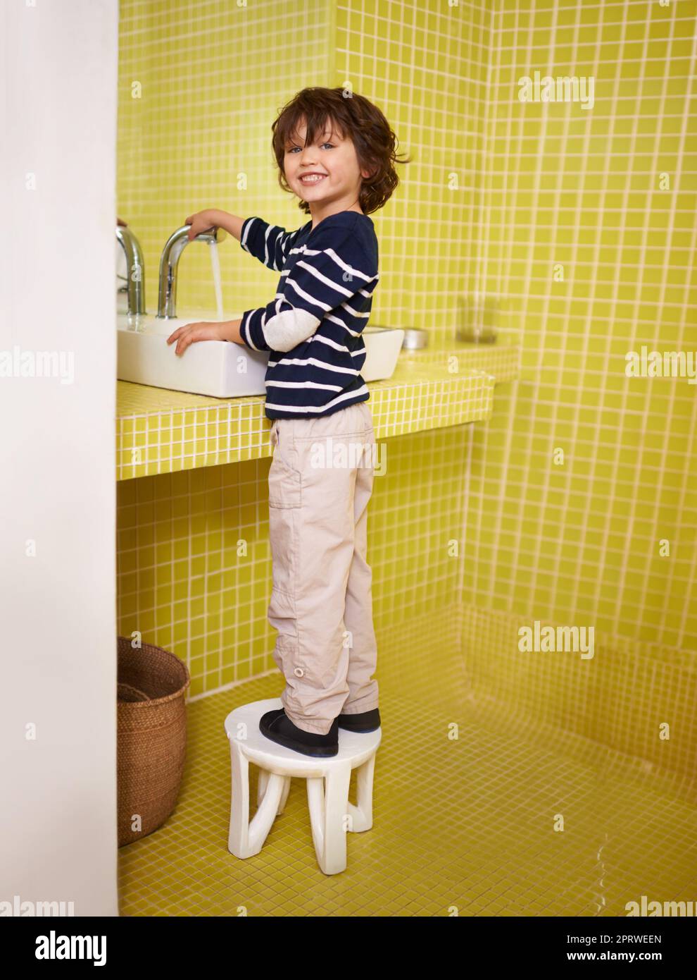 All clean. A cute little boy washing his hands in the bathroom basin. Stock Photo