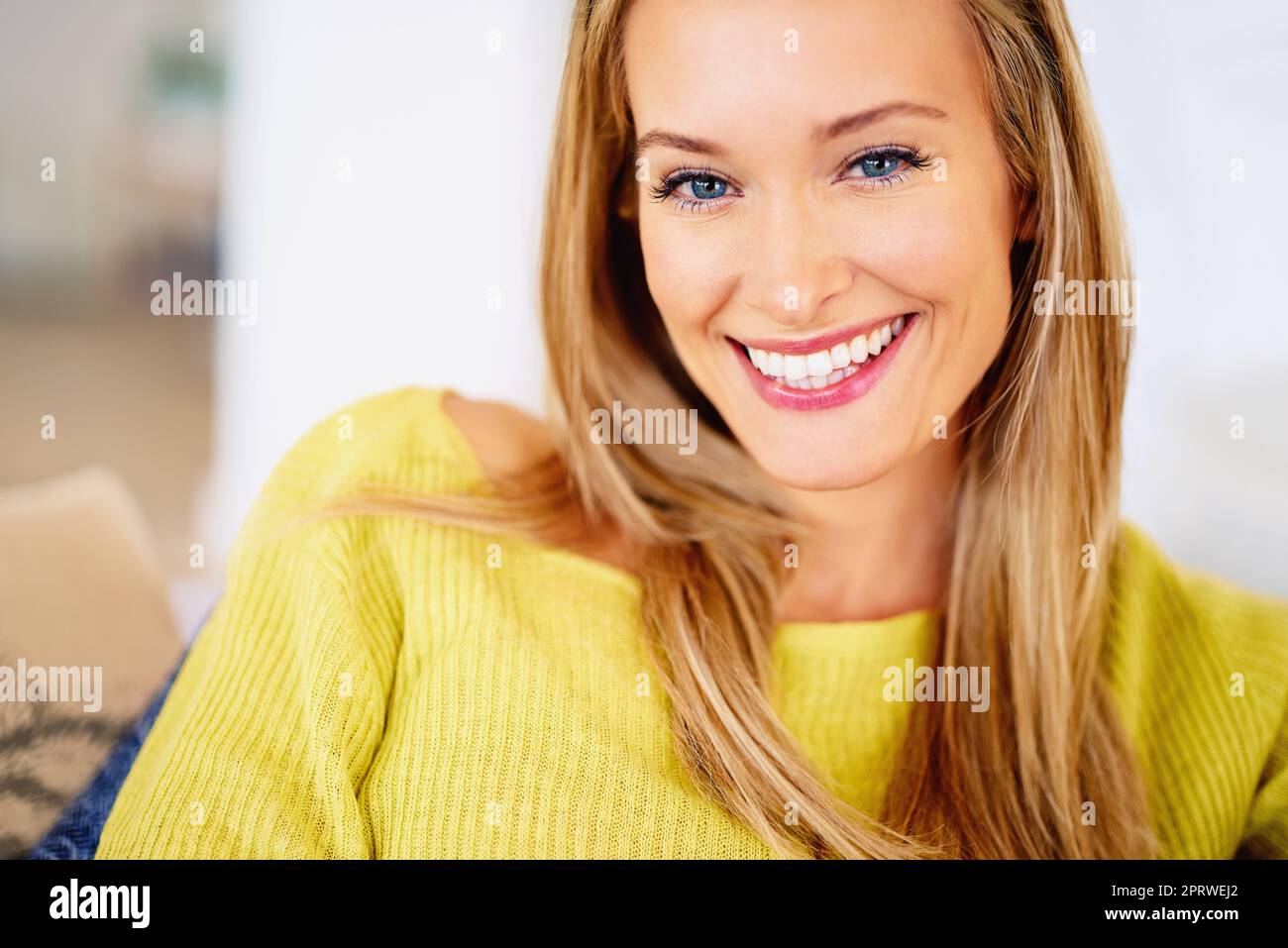 Her beauty is perfect. a happy young woman sitting on her sofa. Stock Photo