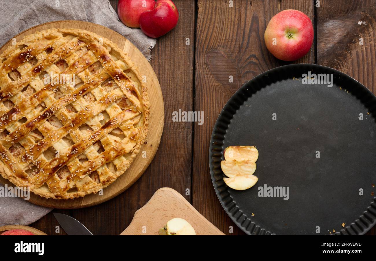 Round baked apple pie on a brown wooden table, top view Stock Photo
