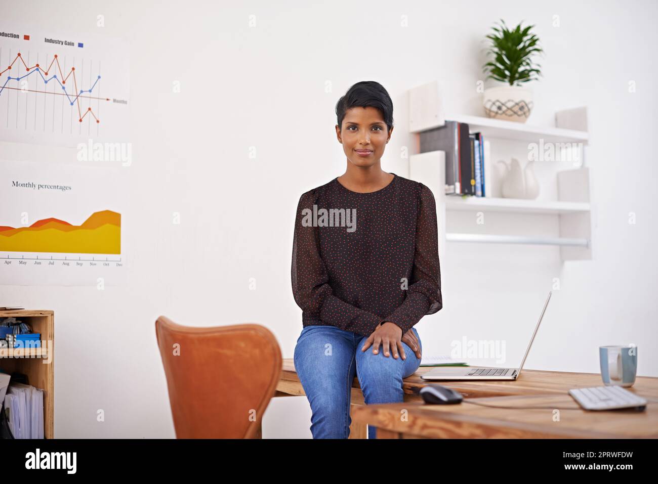 Shes a keen young entrepreneur. A portrait of a beautiful young woman sitting on her desk in her office. Stock Photo