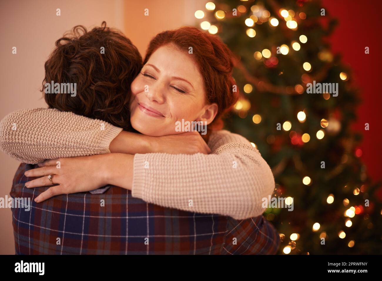 Christmas hug. an affectionate young couple embracing at Christmas time. Stock Photo