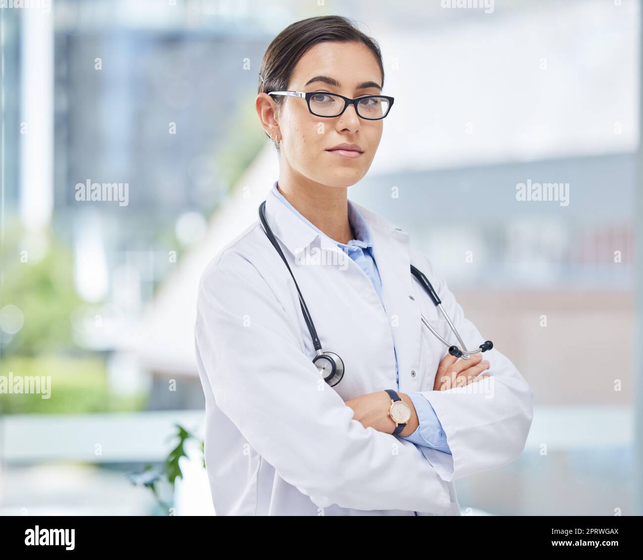 Portrait of a doctor with arms crossed in her consultation office with