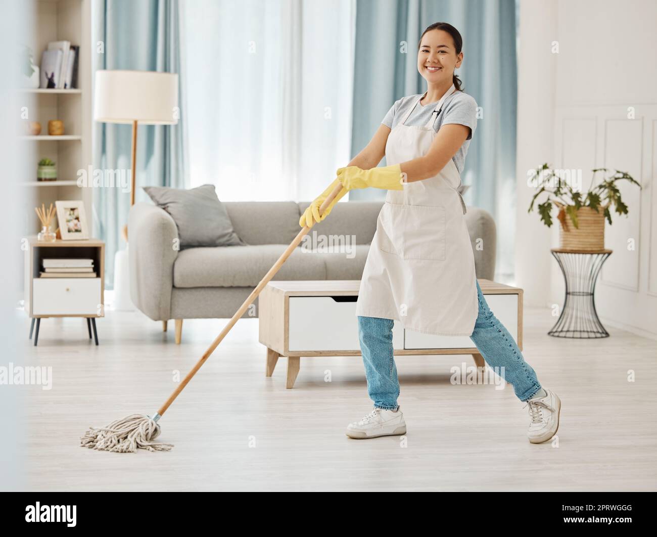 Asian cleaner woman mopping and cleaning dirt and dust in lounge or