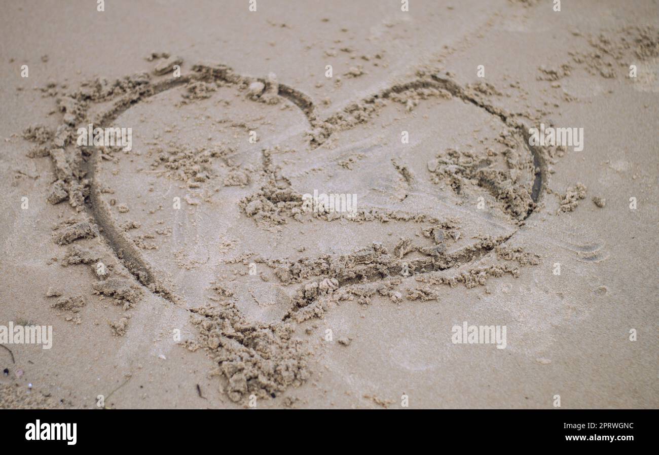 Love sign on sand. Love heart symbol in sand on tropical beach. Holidays Backgrounds Textures. Puri, Odisha, India Stock Photo