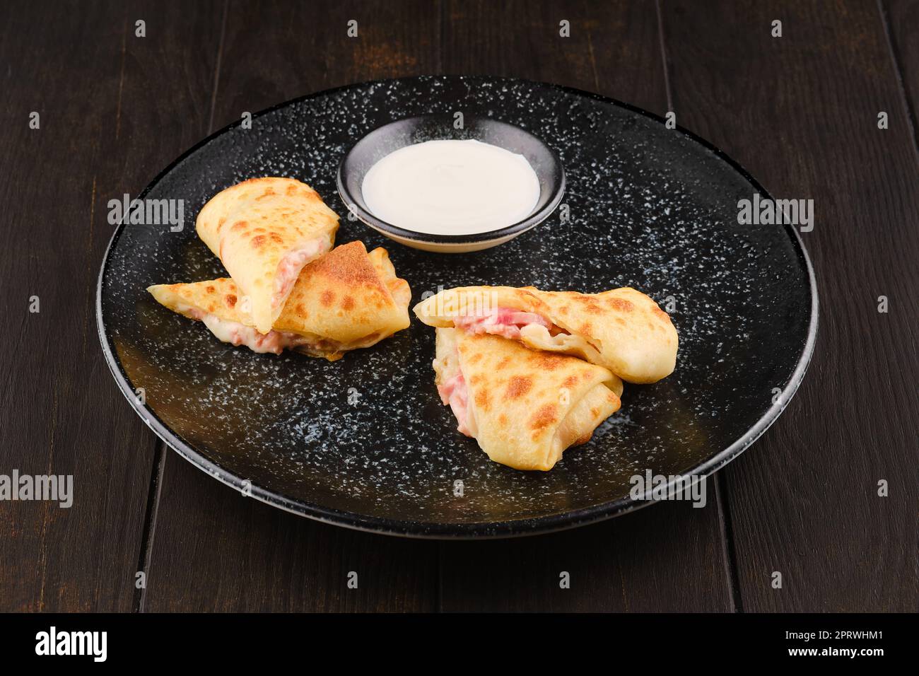 Thin pancakes stuffed with ham and cheese Stock Photo