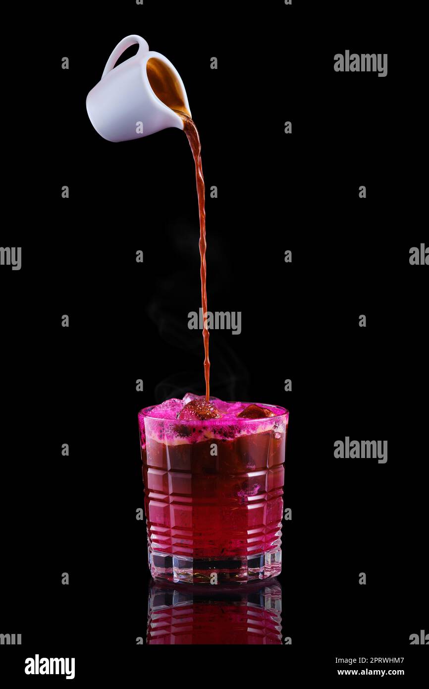 Pouring hot espresso in glass with tonic and dragon fruit syrup Stock Photo