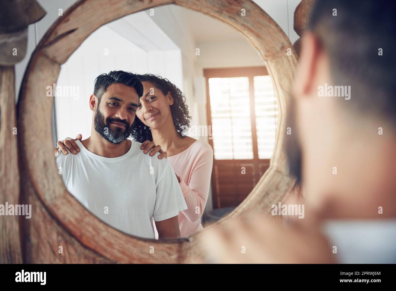 She gets him even when he doesnt get himself. a mature man looking at his  reflection in the mirror with his wife standing proudly behind him Stock  Photo - Alamy