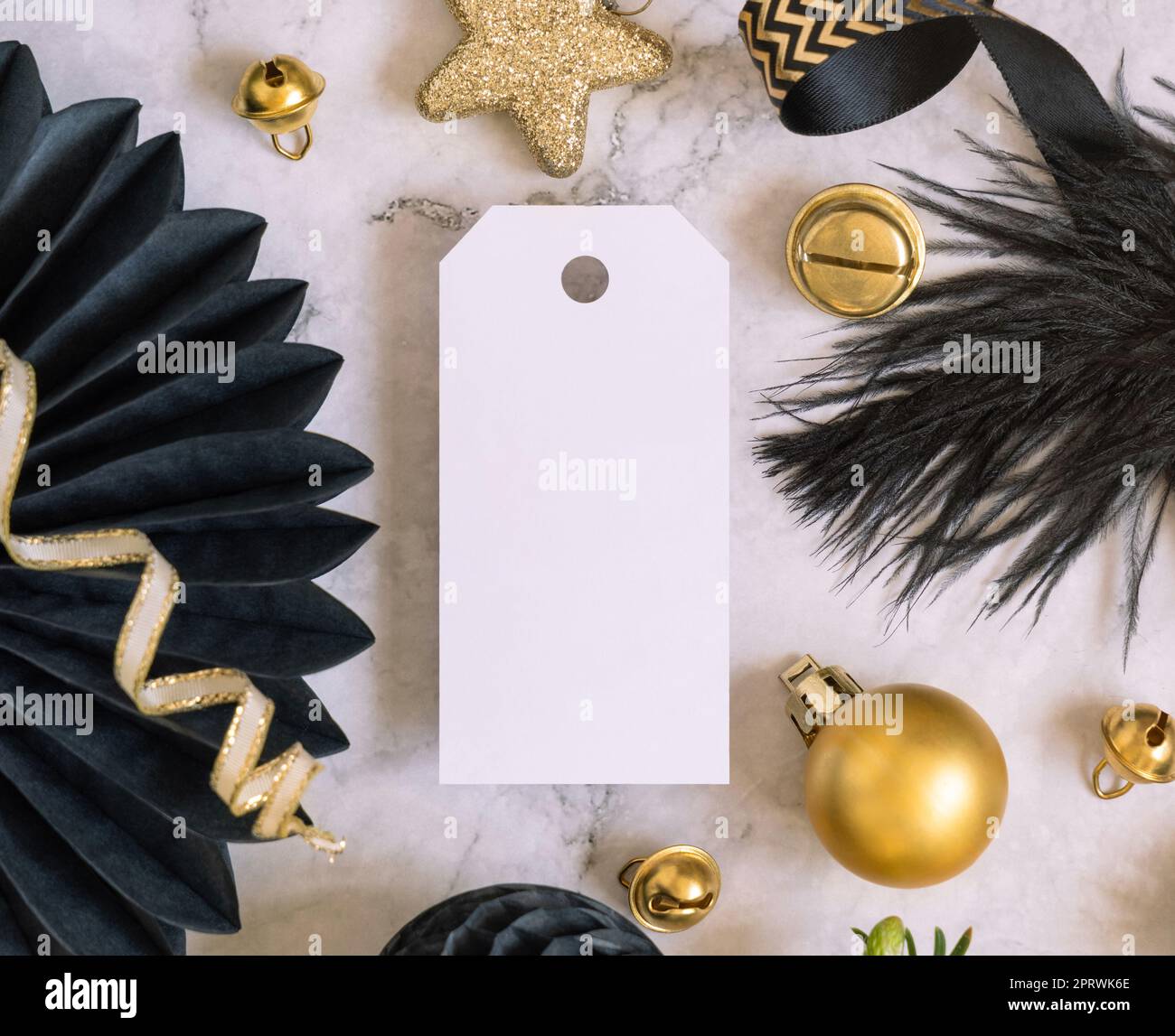 Blank vertical gift tag between black and golden Christmas decorations ...