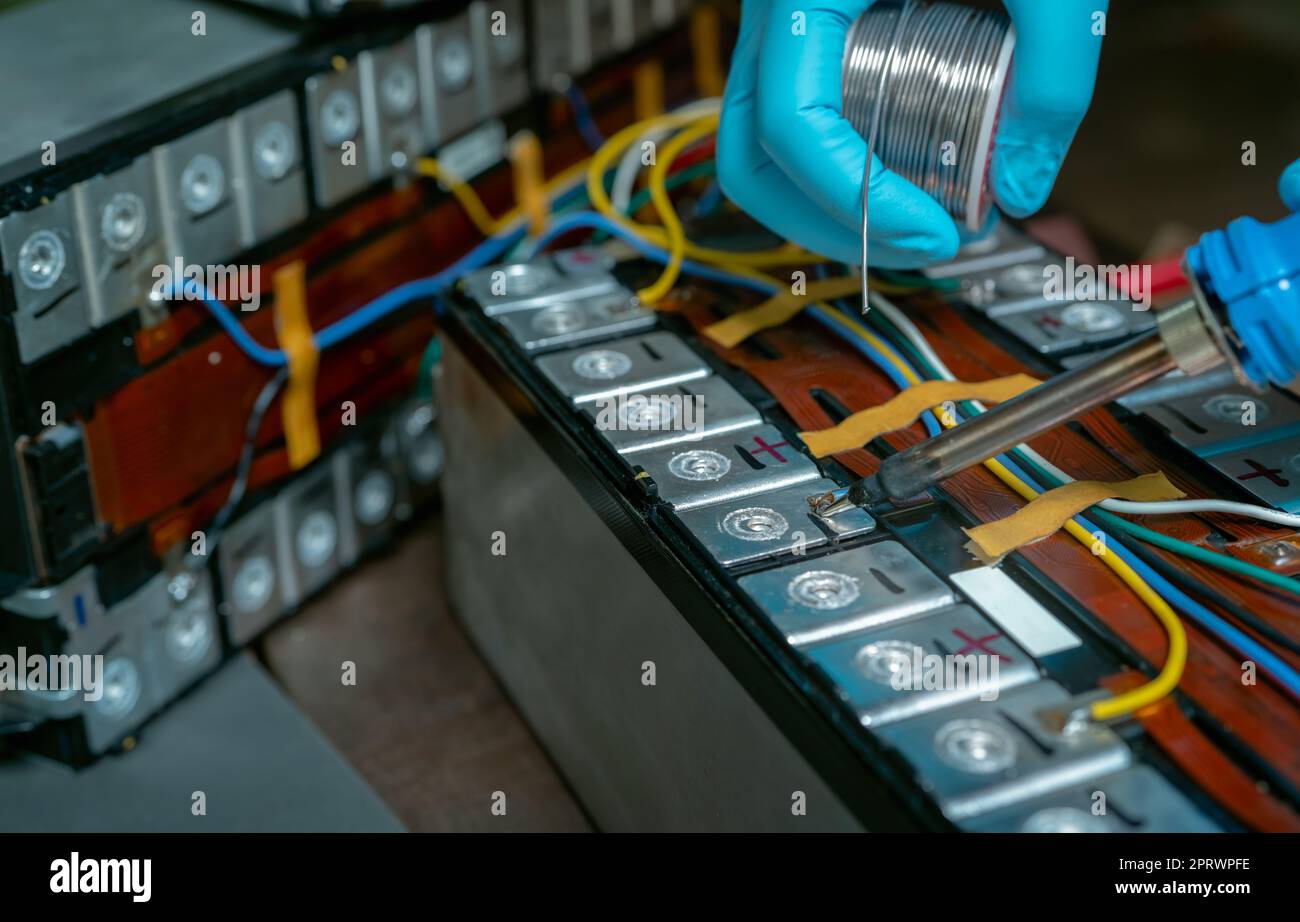 Technician use soldering iron to solder metal and wire of lithiumion