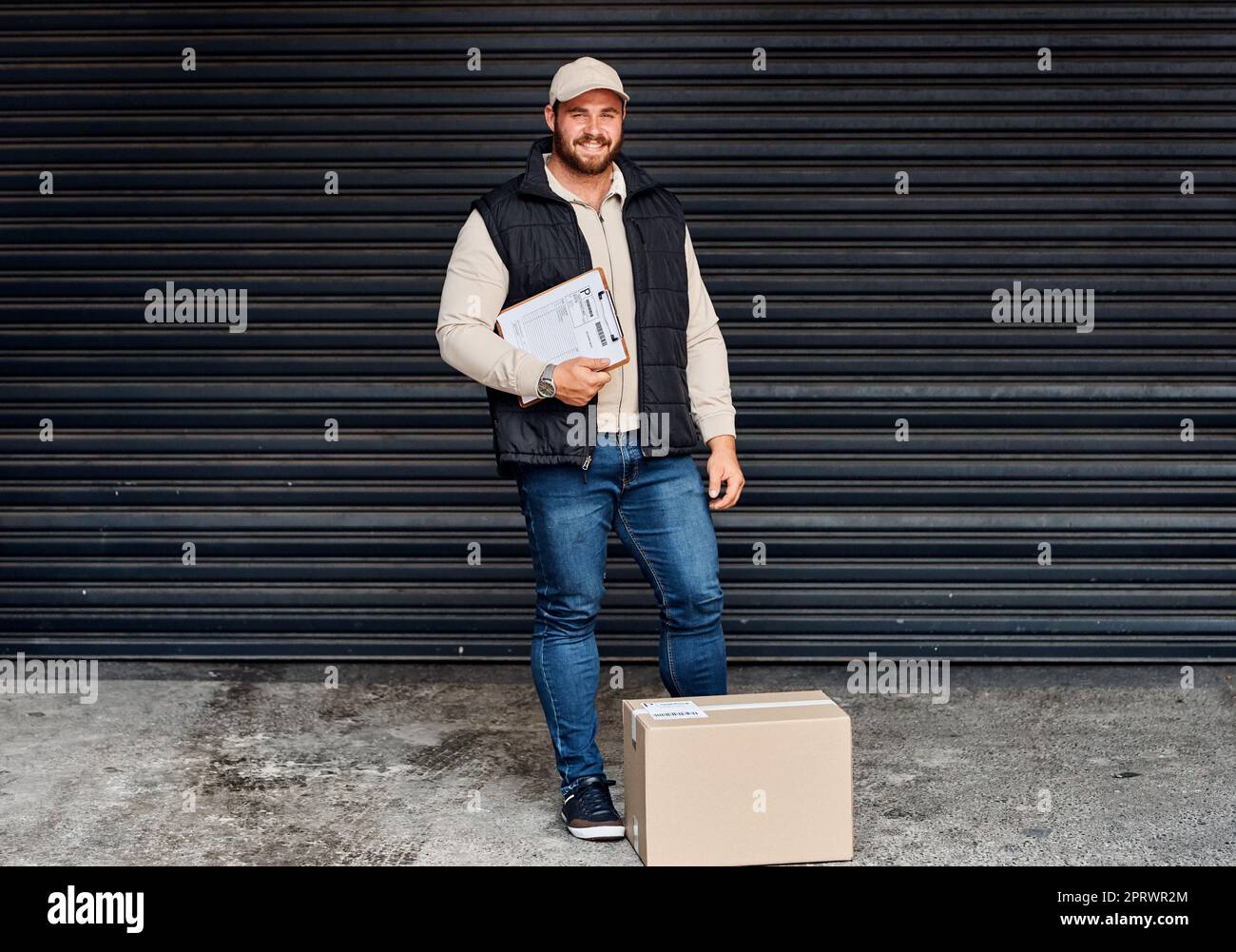 You can ship with certainty with us. Portrait of a courier holding a clipboard. Stock Photo