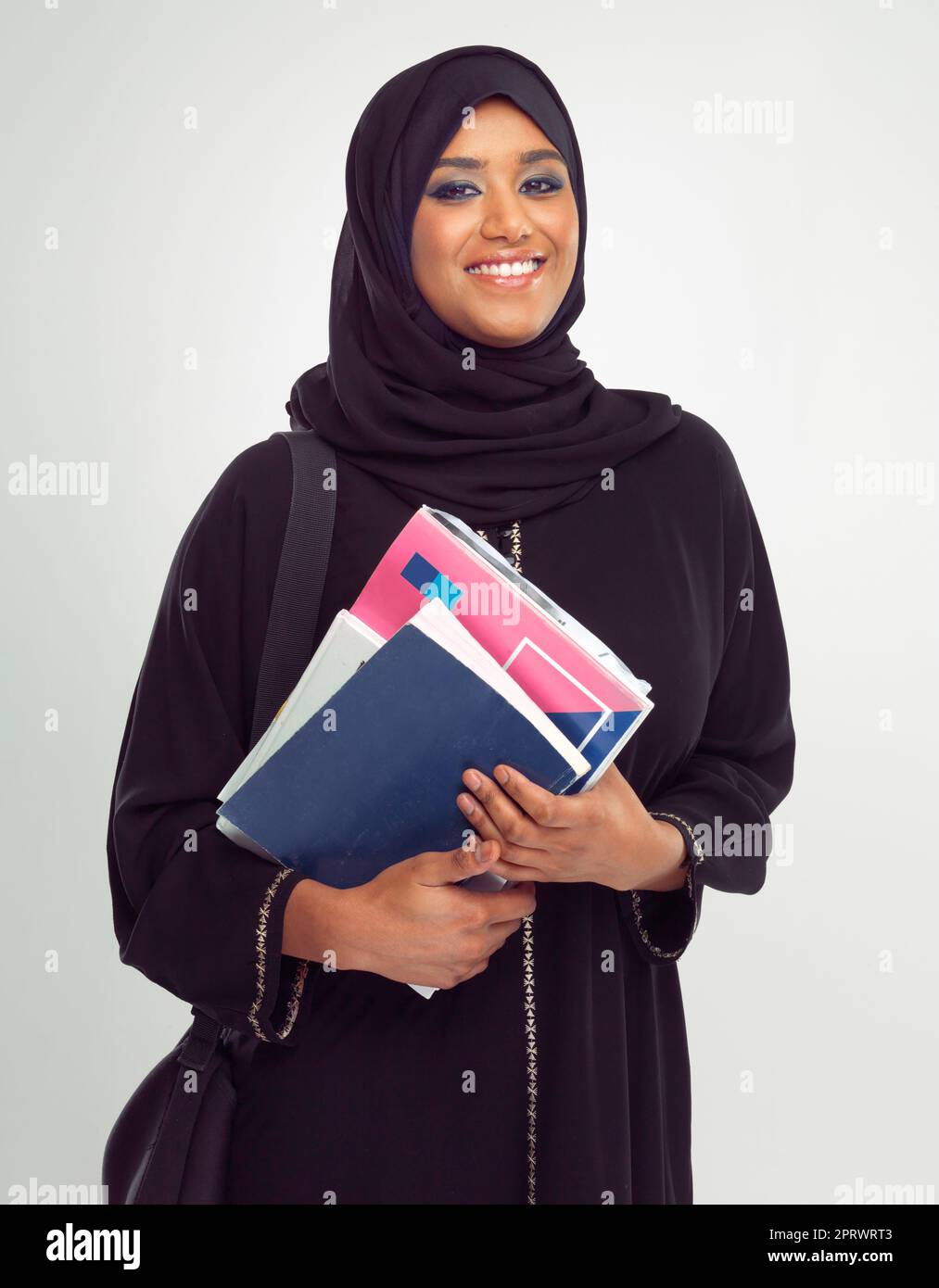 Shes an A student. Portrait of a young muslim woman wearing a burqa holding documents. Stock Photo