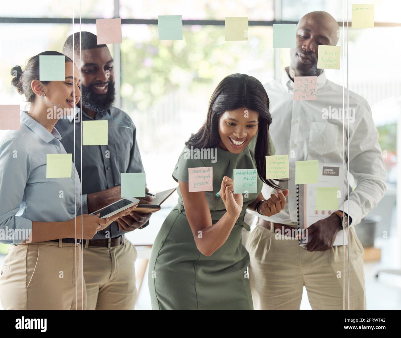 Sticky note, planning meeting and business people thinking of creative idea, writing strategy on paper and happy with team building goal in office. Corporate employees with smile working on schedule Stock Photo