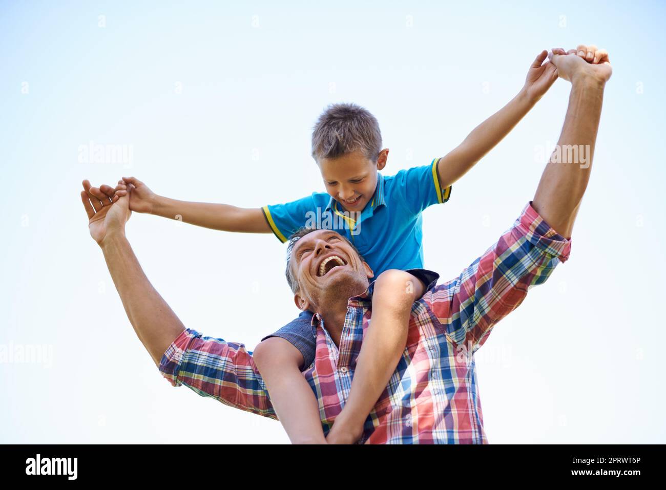 Dads pride and joy. A low angle shot of a happy father carrying his young son on his shoulders. Stock Photo
