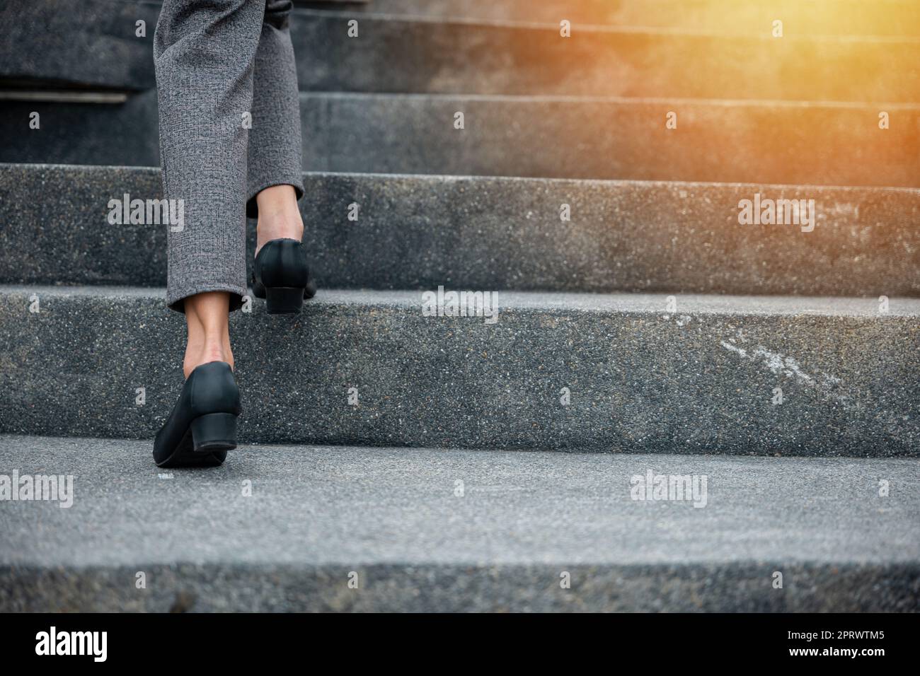 Closeup legs of businesswoman hurry up walking on stairway Stock Photo