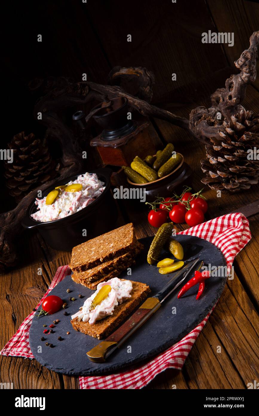delicious spicy meat salad with cucumber on the black bread Stock Photo