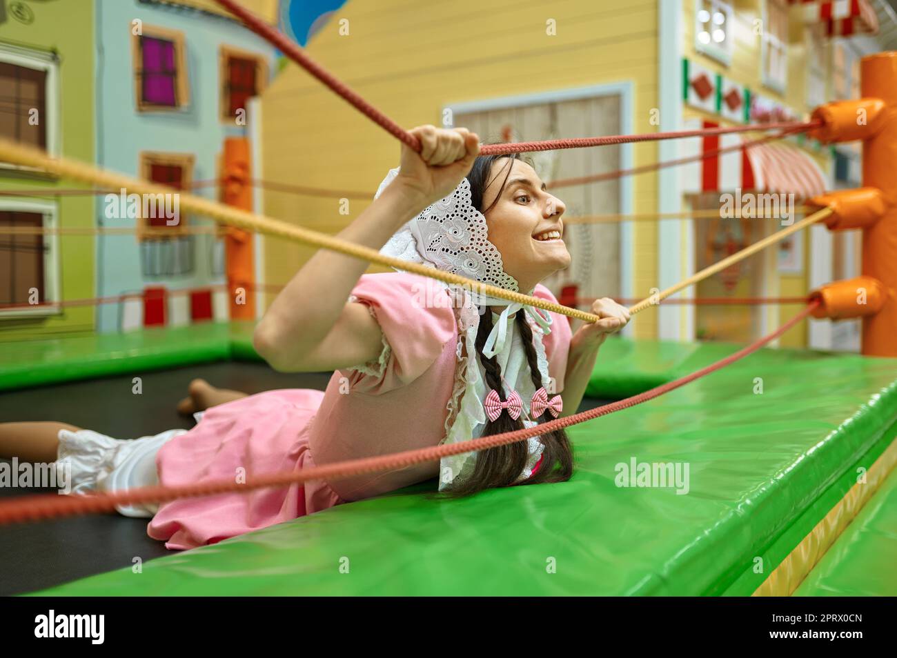 Funny woman like baby having fun in daycare center Stock Photo