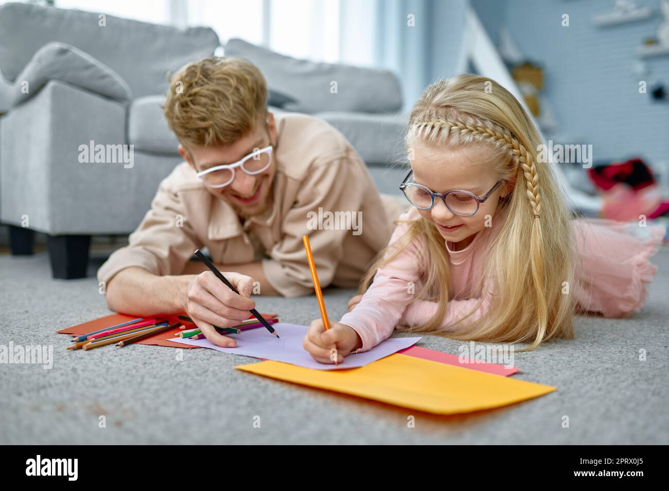Father and daughter drawing on floor Stock Photo