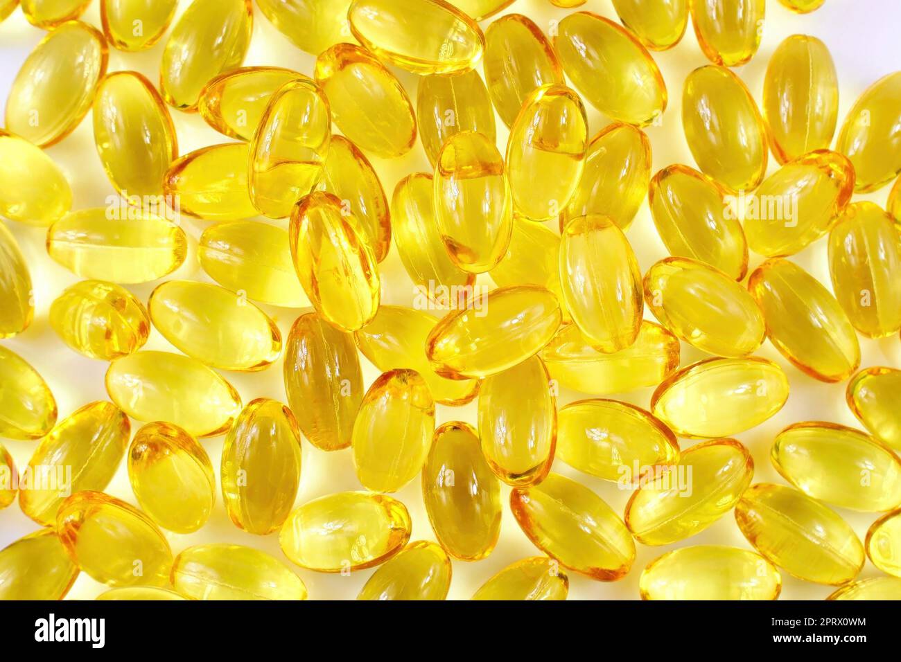 Top view of bright yellow vitamin E oil capsules texture close up Stock