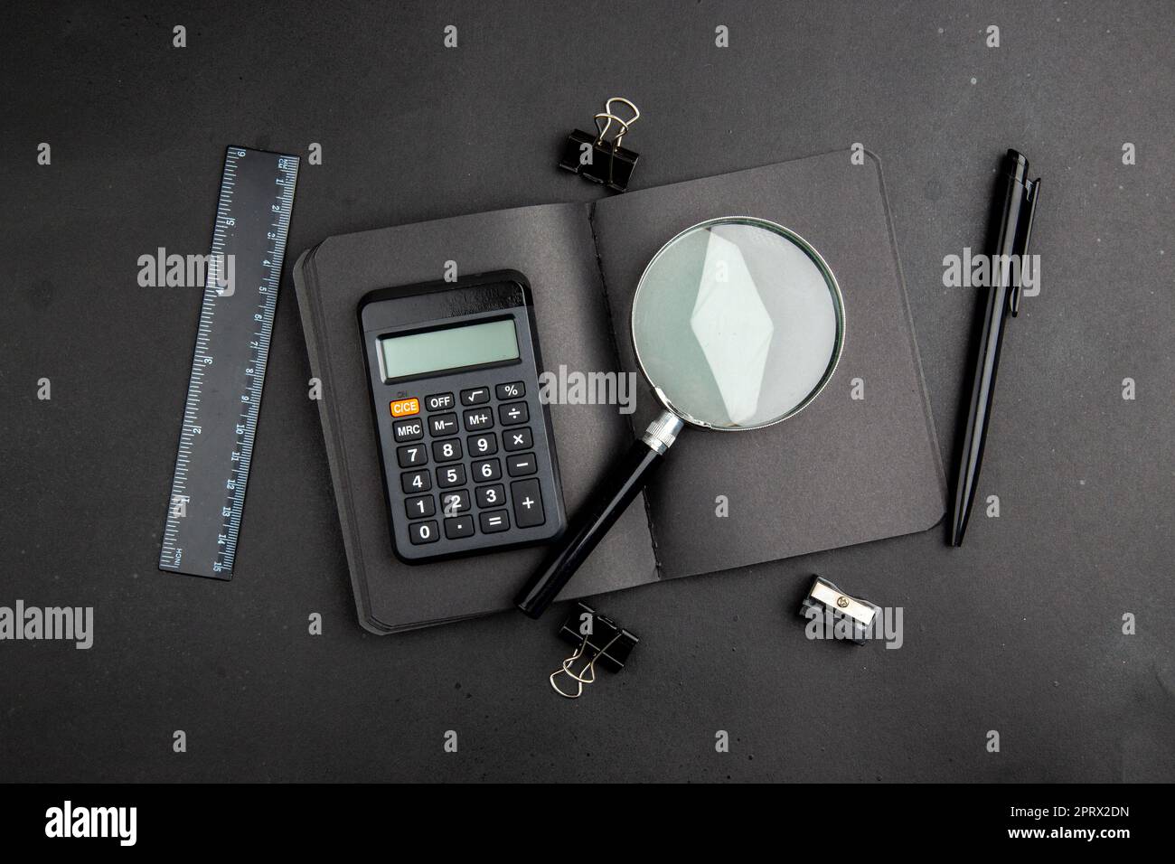 top view office stuffs calculator lupa on notepad ruler pen binder ...