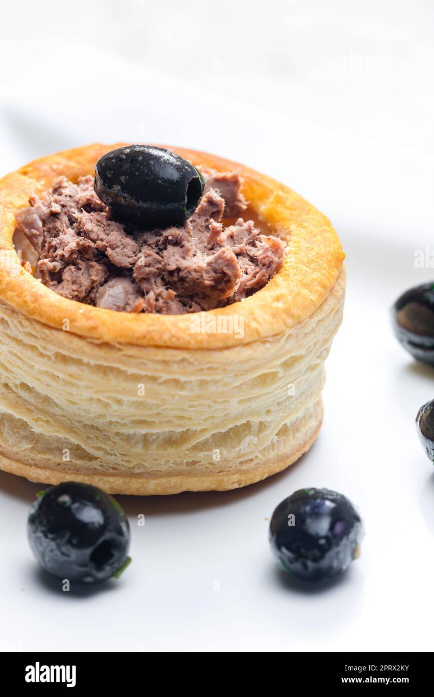 puff pastry filled with terrine served with black olives Stock Photo
