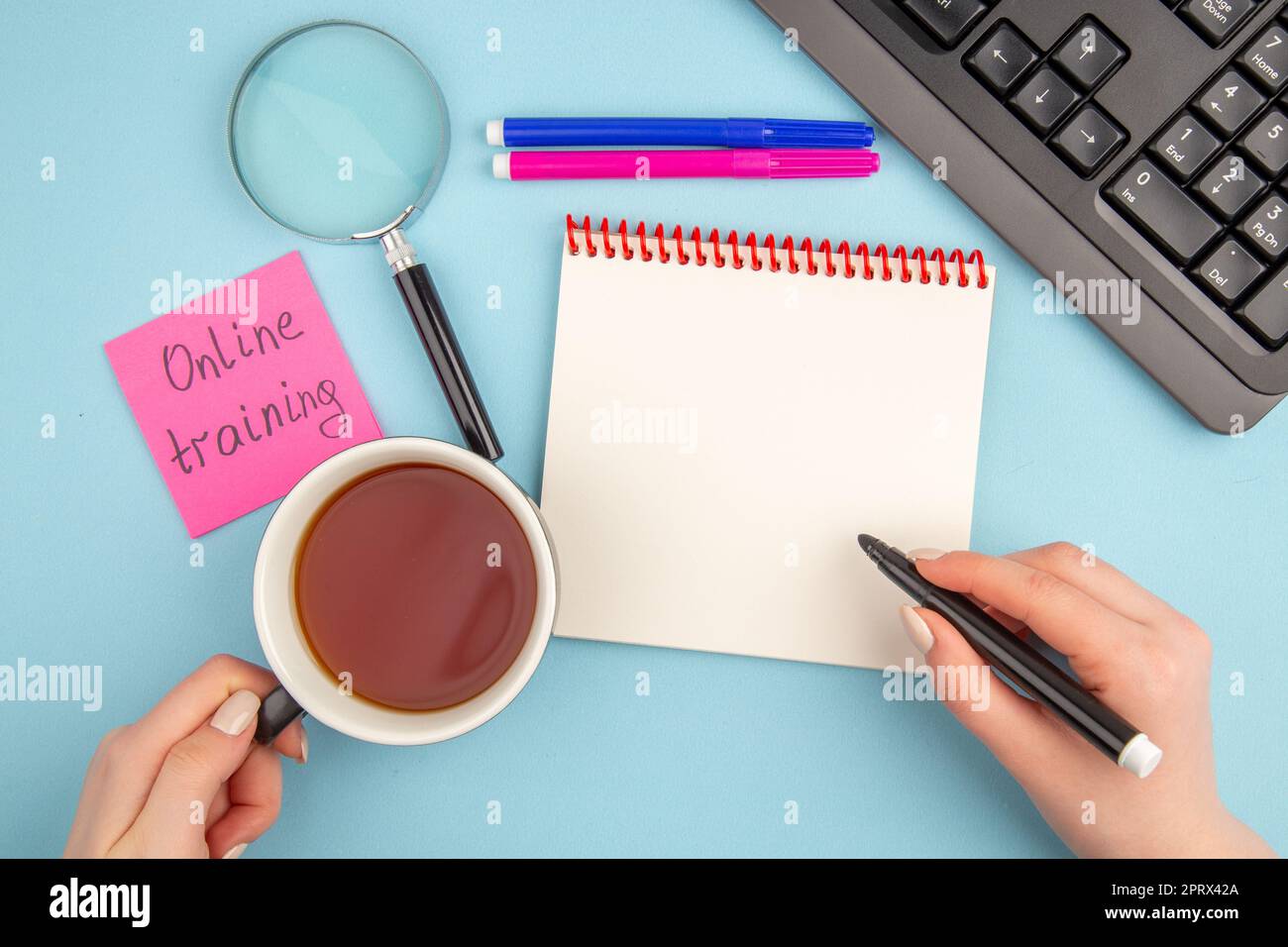 top view online training written on sticky note cup of tea and marker ...