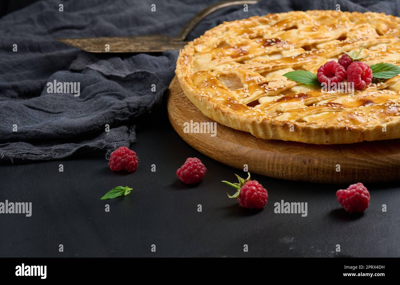 Round baked apple pie on a black table. Stock Photo