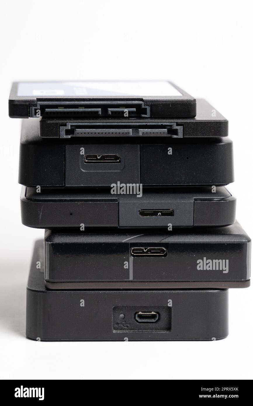 A stack of external USB hard drives on a white background. Stock Photo