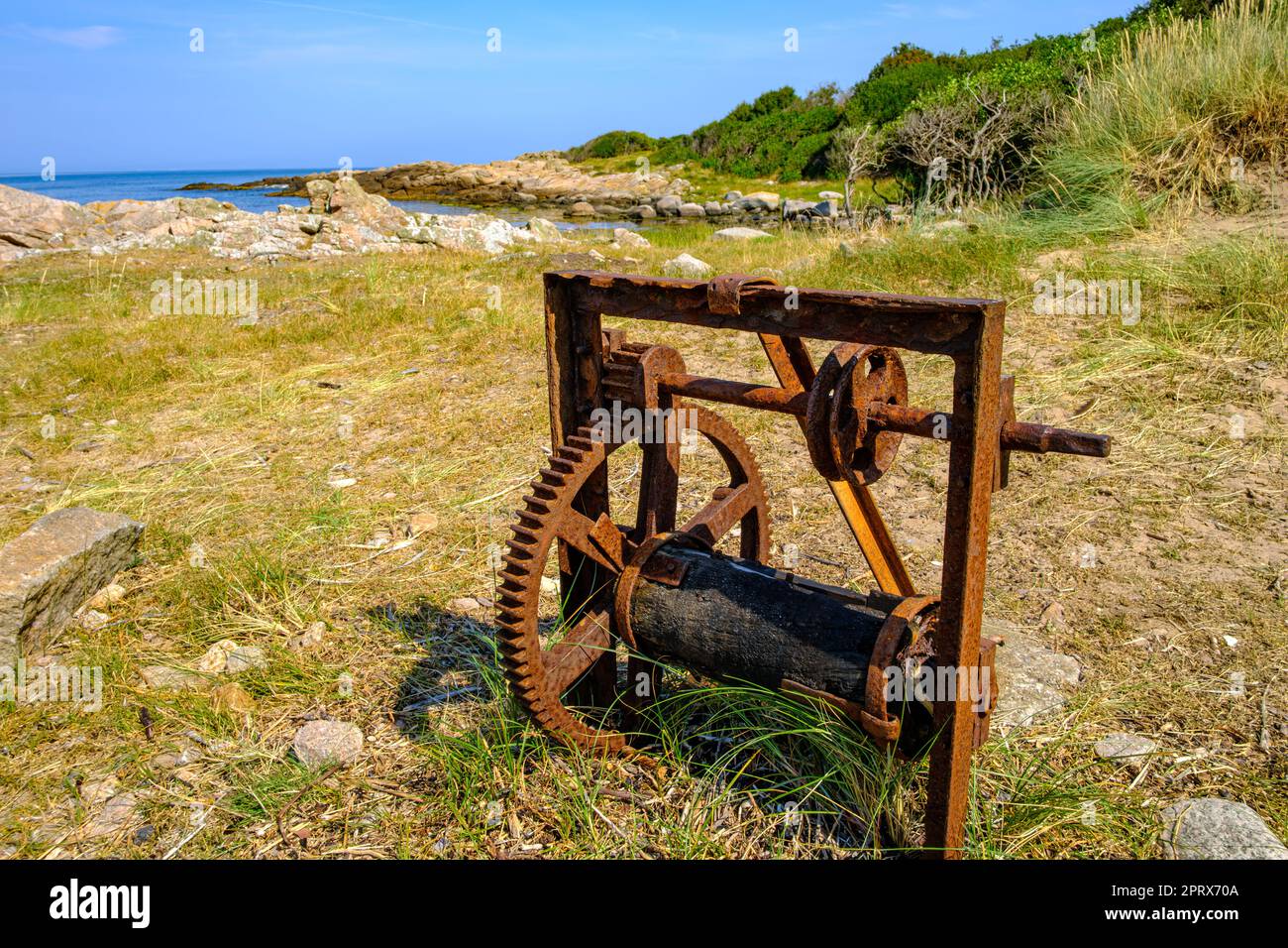 Old weathered rusty winch on the west coast of Hammeren headland at the northern tip of Bornholm Island, Denmark, Scandinavia, Europe. Stock Photo