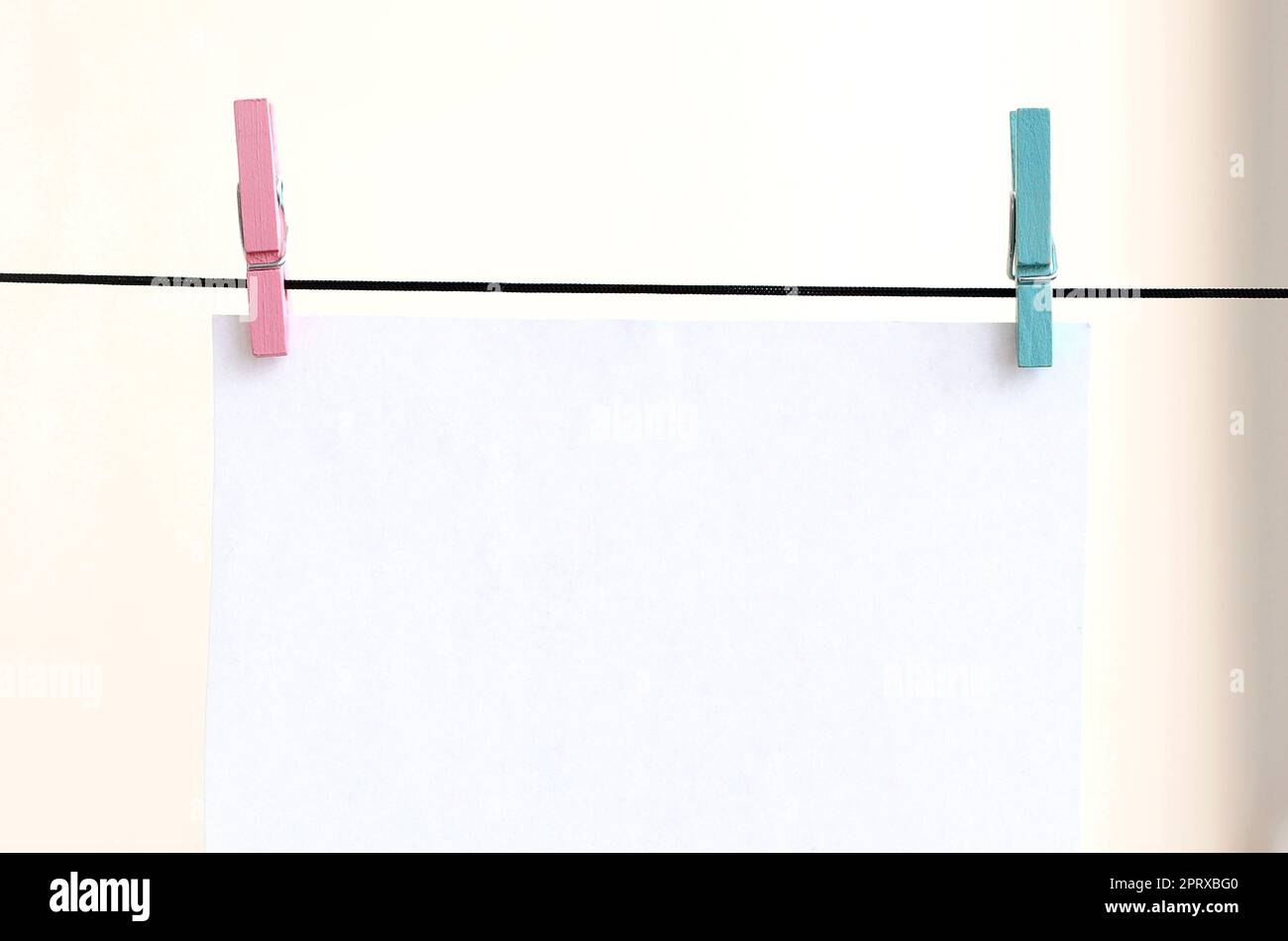 Concept image of tiny clothespins holding different color notes on  clothesline. Isolated on white background Stock Photo - Alamy