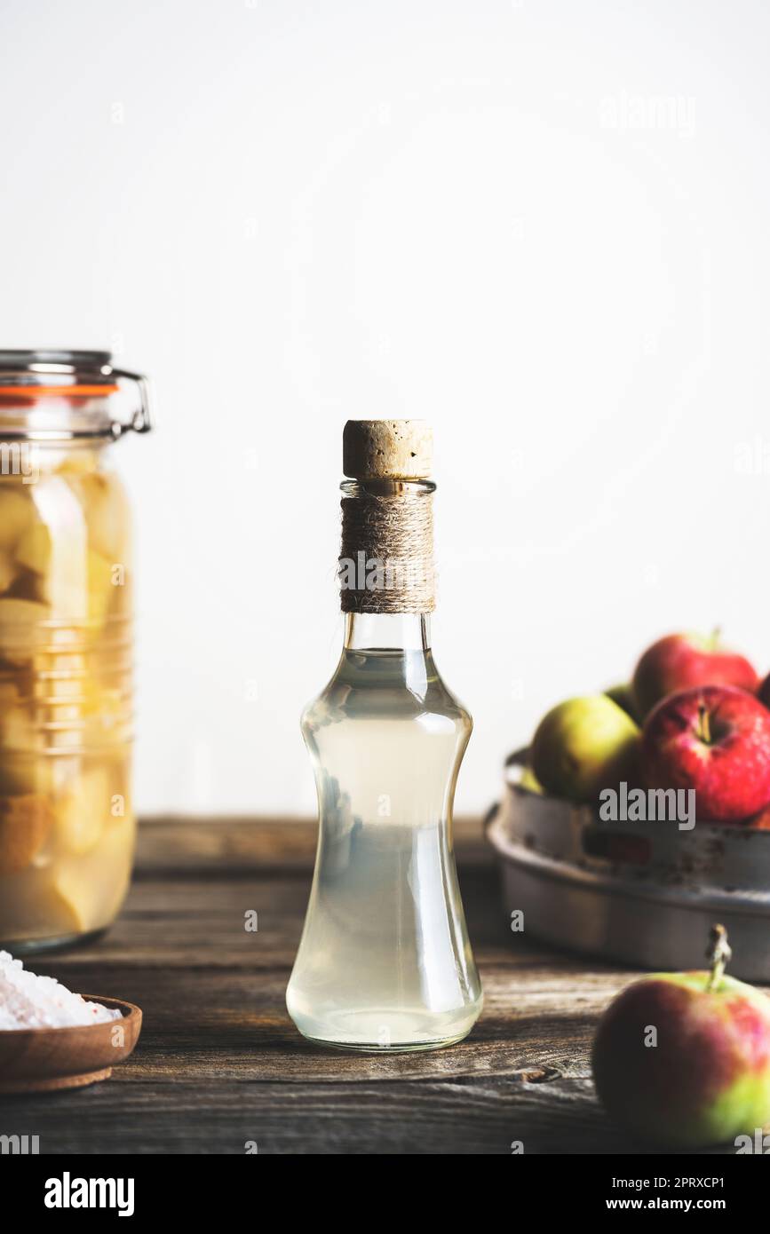 Bottle of apple cider vinegar on white background with ripe apples and ...