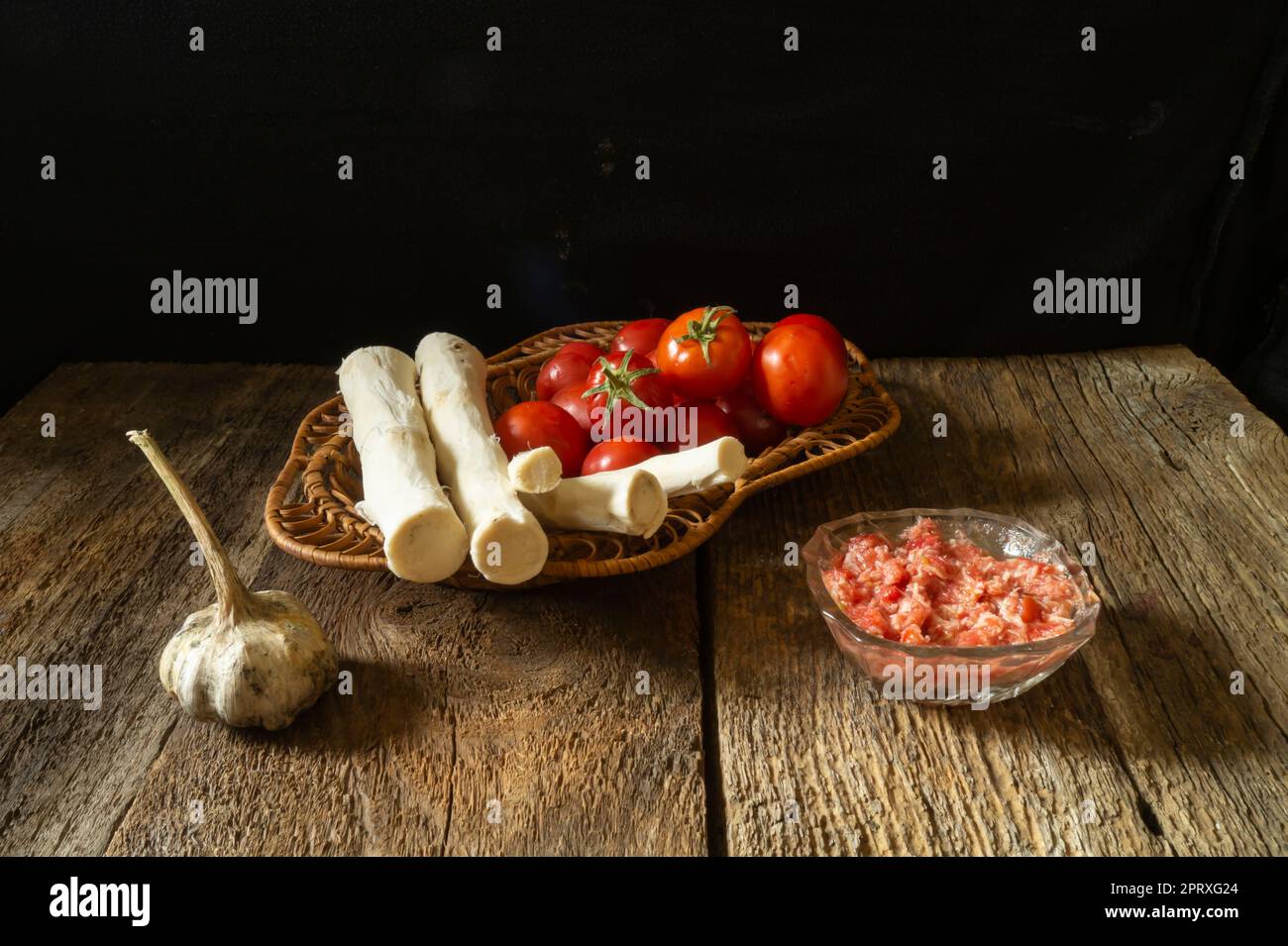 Tomatoes and horseradish root for making a spicy seasoning. Ripe vegetables on a dark background Stock Photo