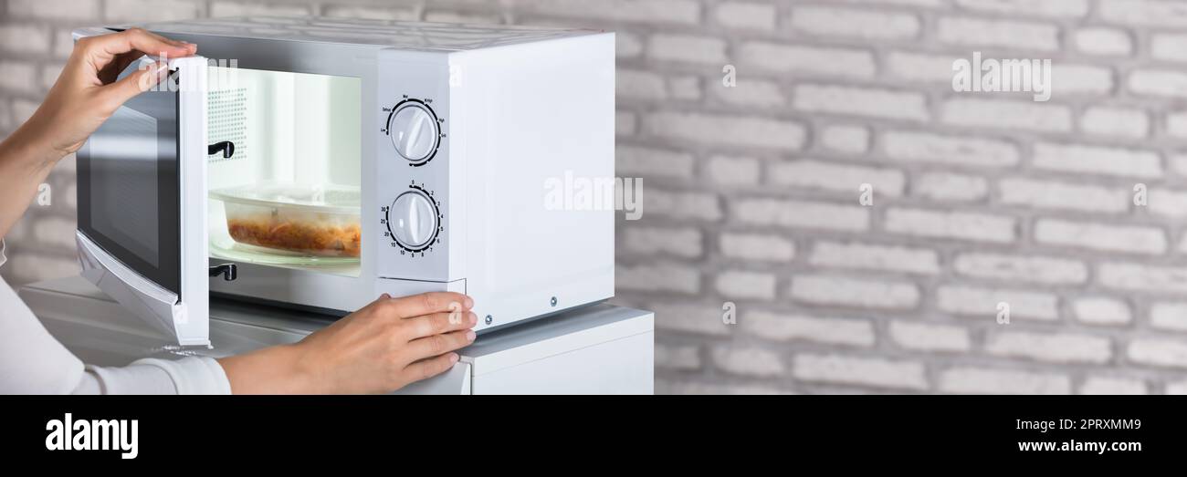 Woman Using Open Microwave Oven. Heating Food Stock Photo Alamy