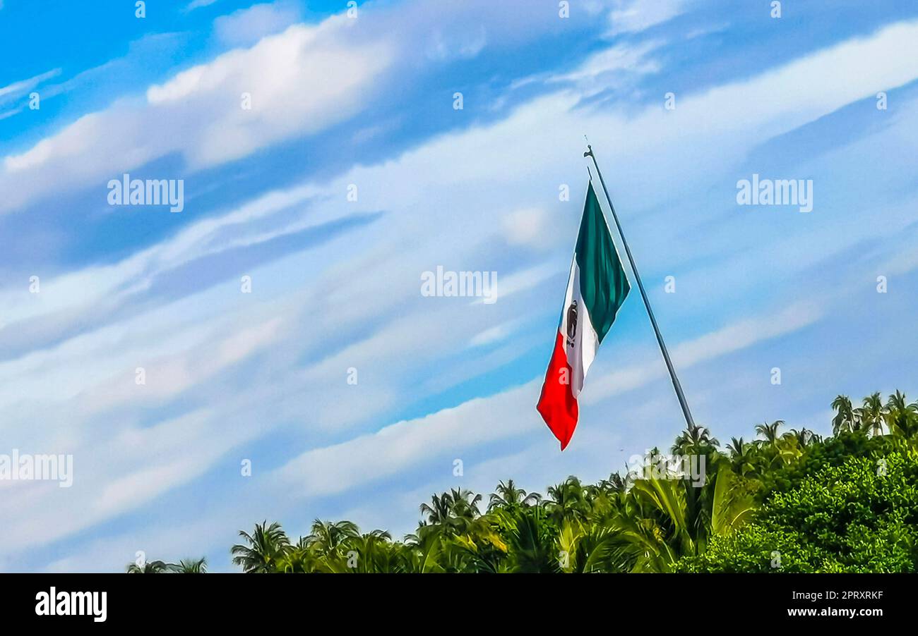 Mexican green white red flag with palm trees and blue sky and clouds in