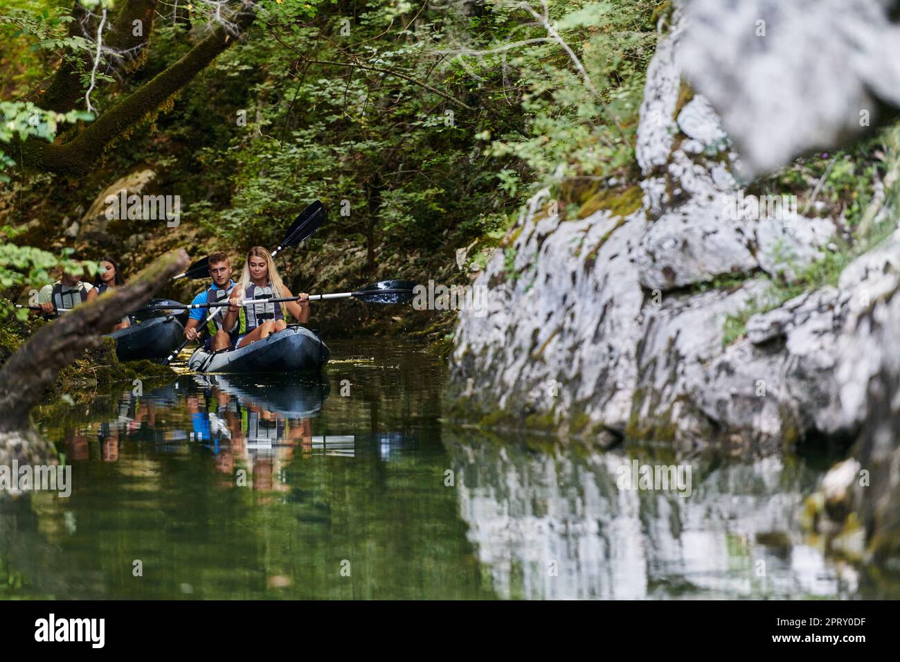 A young couple enjoying an idyllic kayak ride in the middle of a ...